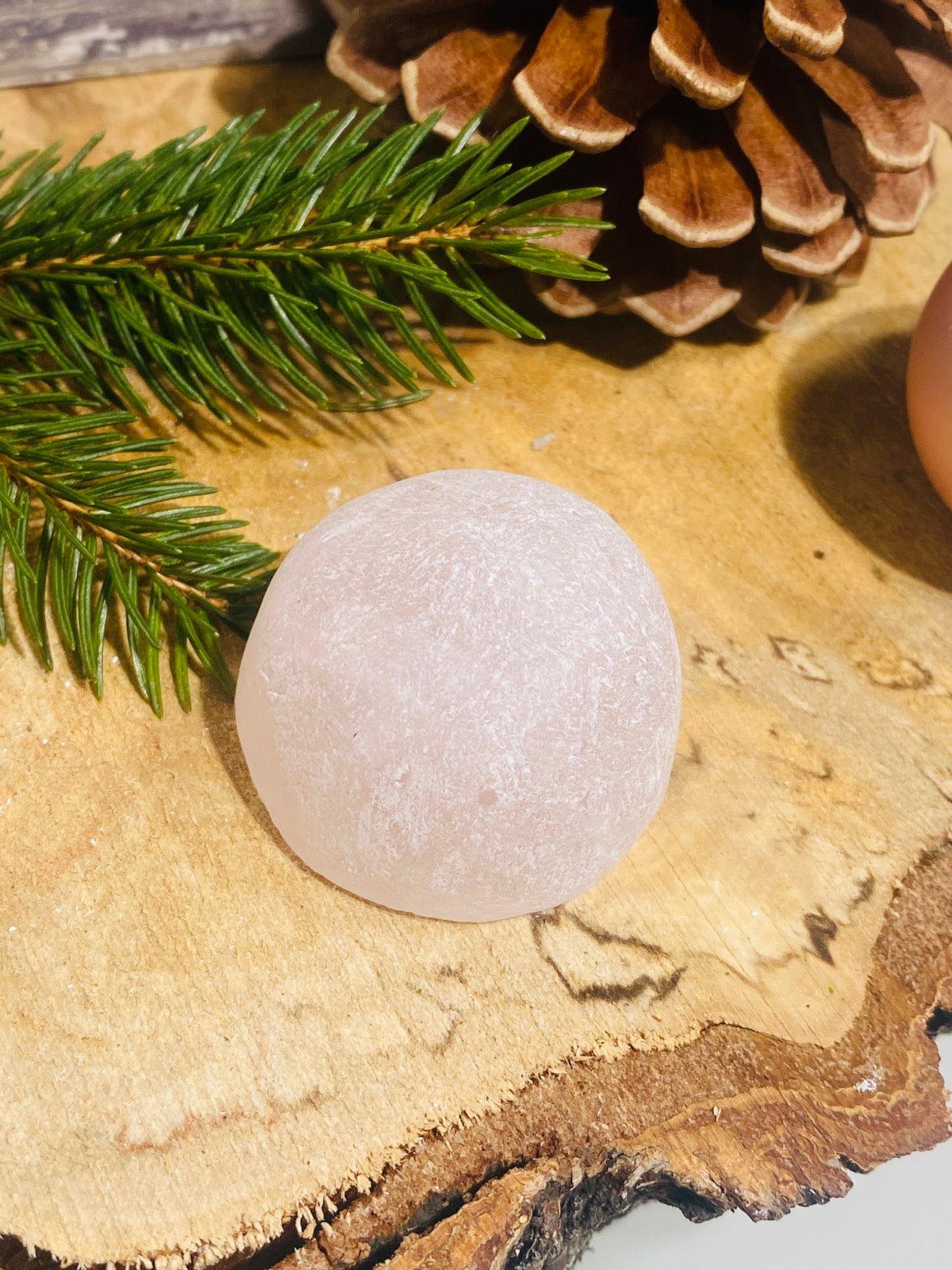 ROSENQUARZ Emu Egg auf Holzplatte mit Weihnachtsdekoration